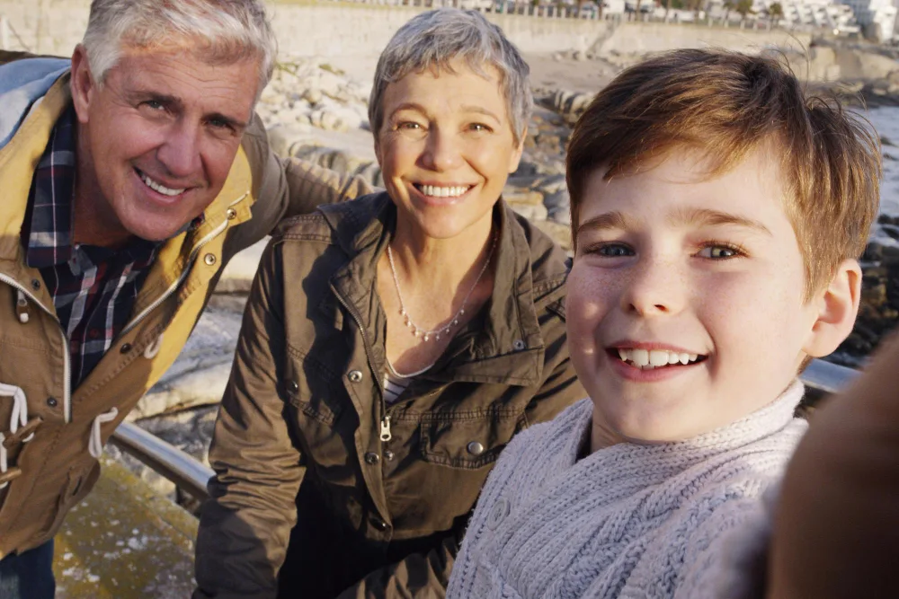 Three generations of a smiling family outdoors