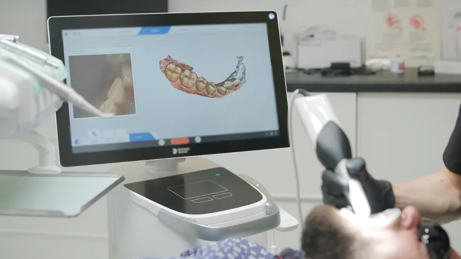Dentist using an intraoral scanner to review a patient's 3D dental scan